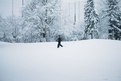 Man walking on snow covered field