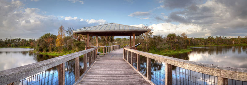 Sunset over gazebo on a wooden secluded, tranquil boardwalk along a marsh pond in freedom park 