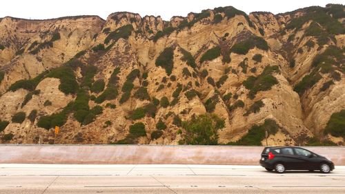 Side view of vehicle against rocks