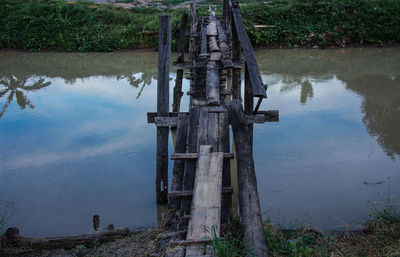 Wooden post in lake by trees in forest