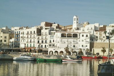 Boats in river with buildings in background