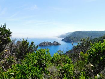 Scenic view of sea and mountains against sky