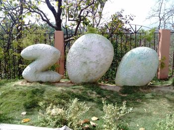 Sculpture on grass against trees