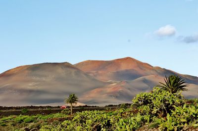 Scenic view of mountains against blue sky