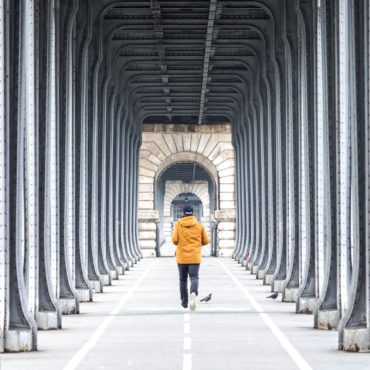 FULL LENGTH REAR VIEW OF WOMAN WALKING IN ARCHWAY