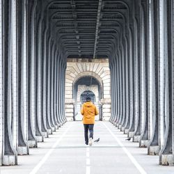 Full length rear view of woman walking in corridor