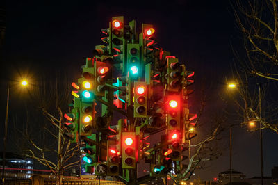 Low angle view of illuminated street lights at night