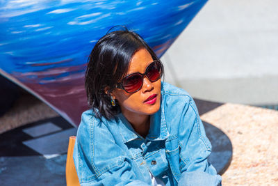 Woman wearing sunglasses sitting outdoors