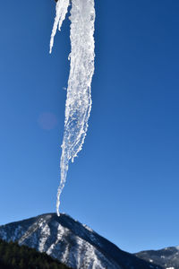 Low angle view of vapor trail against clear blue sky