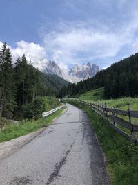 Road leading towards mountains against sky