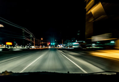 Illuminated road in city at night