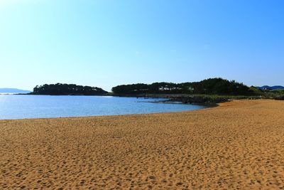 Scenic view of beach against blue sky