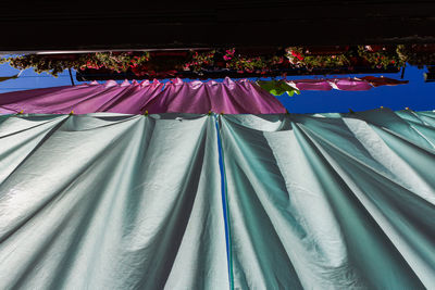 Low angle view of clothes drying against blue sky