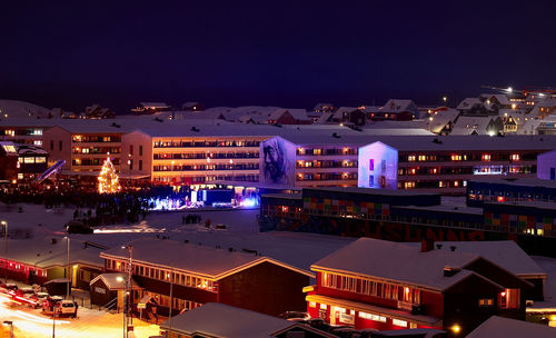 High angle view of illuminated buildings against sky at night