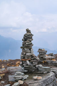Stack of rocks on land against sky