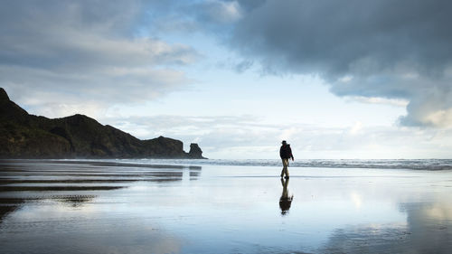 Man standing on beach against sky