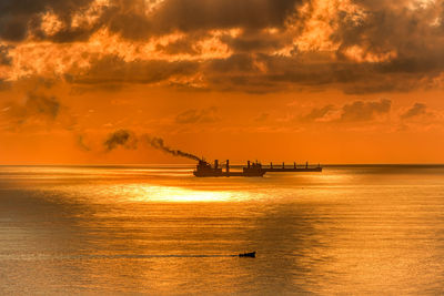 Silhouette boat in sea against sky during sunset