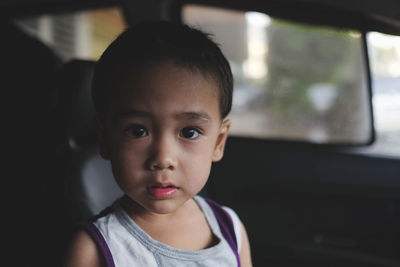 Portrait of cute boy sitting in car