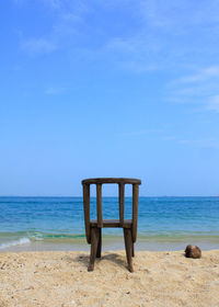 Lifeguard chair on beach against clear blue sky
