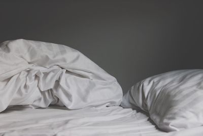 Pillows on crumpled bed at home