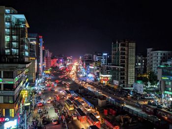 High angle view of traffic on city street and buildings at night