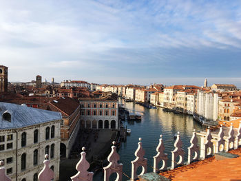 High angle view of buildings by river against sky