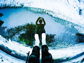 Low section of person standing on snow covered road