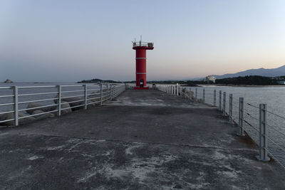 Lighthouse by sea against sky