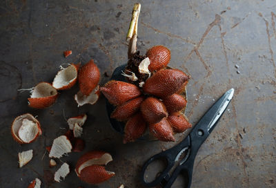 Directly above of snake fruits and scissors on table