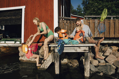 Father with children sitting on pier during summer vacations