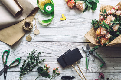 Top view of flowers and scissors with ribbons on table