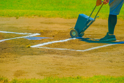 Low section of man skateboarding on field