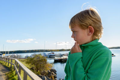 Boy looking at camera against sky