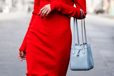 Midsection of woman holding bag