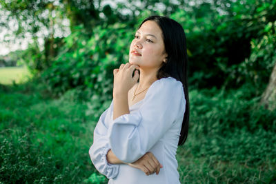 Side view of a young woman standing on field