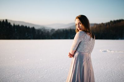 Woman standing on snow covered land