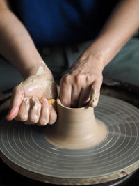 Woman starts to create a ceramic cup on the pottery wheel. working with clay on potter's wheel.