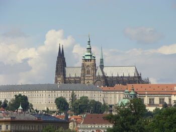 Buildings in city against cloudy sky