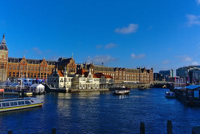 Sailboats in sea against buildings in city