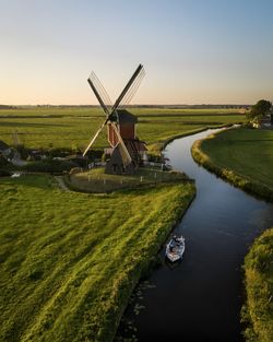 Traditional windmill on field against sky