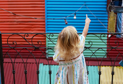 Back view of little baby girl looking at colourful houses in front of her