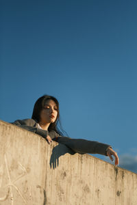 An asian girl on a rooftop. sunset light. golden hours. blue sky background. 
