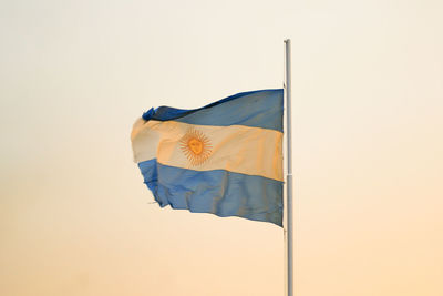 Low angle view of flag against clear sky during sunset