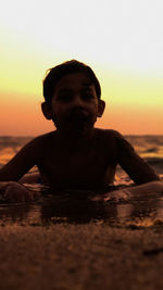 Portrait of man at beach against sky during sunset