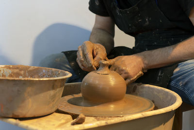 Potter making ceramic mug on the pottery wheel