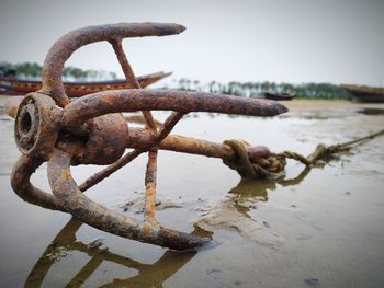 Close-up of rusty chain on beach