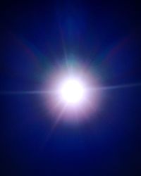 Low angle view of bright sun in blue sky