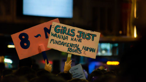 People holding placards with text during protest at night