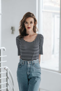 Portrait of beautiful young woman standing at home