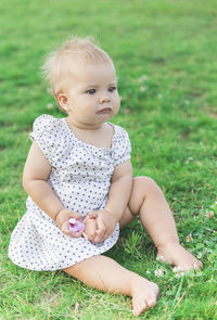 Portrait of cute baby boy sitting on grass